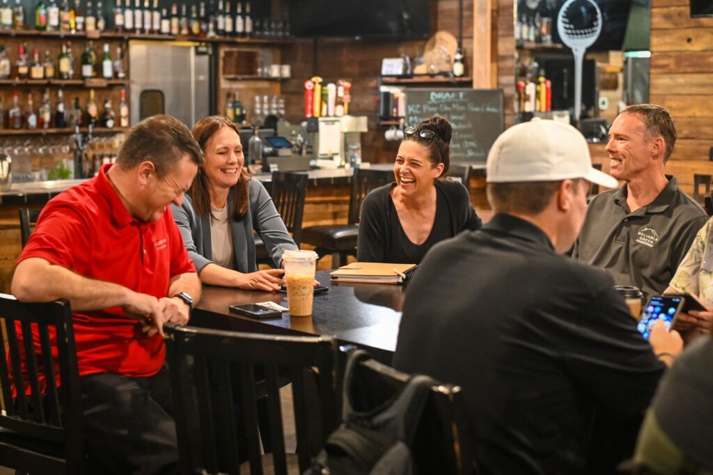 TIBA members talking around high-top tables at a brewery